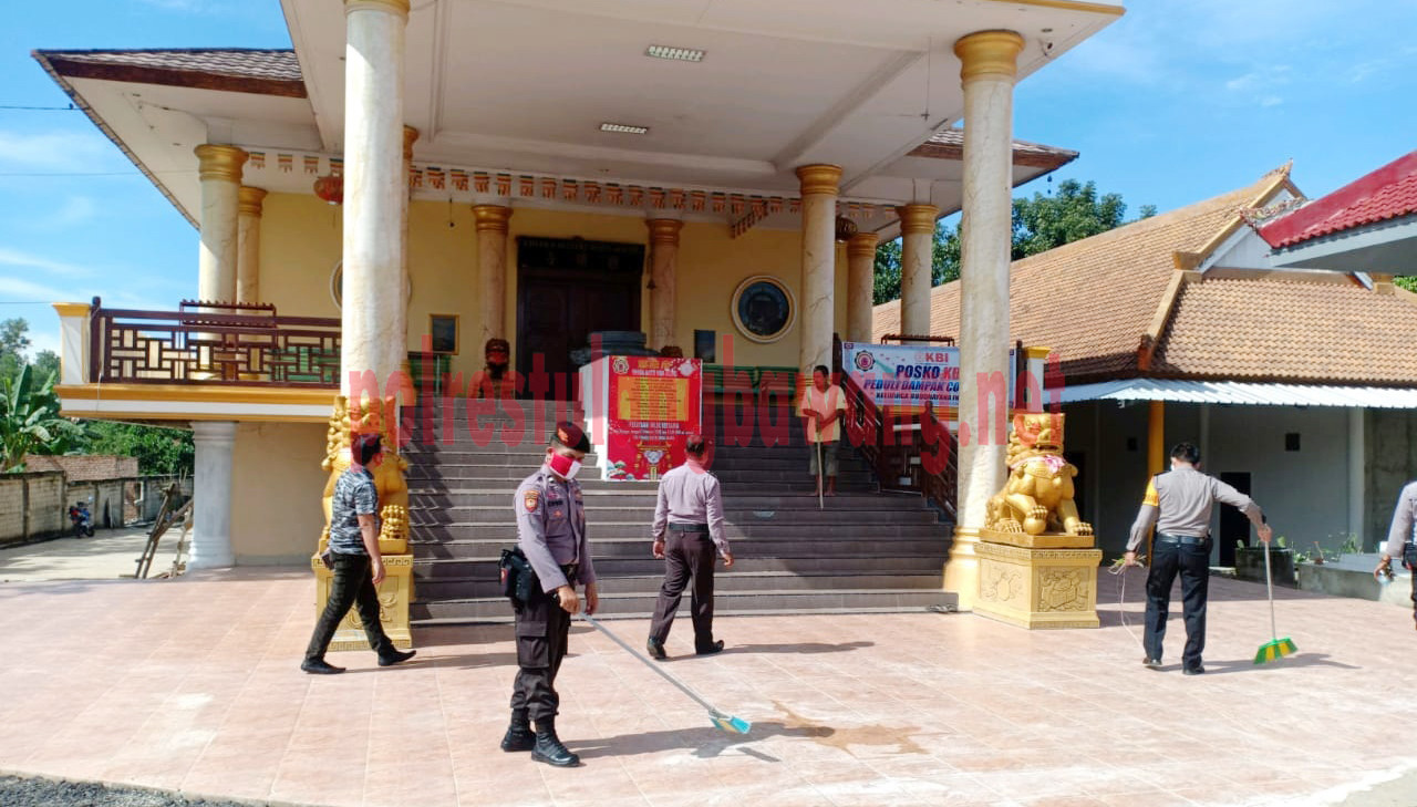 Personel Polres Tulang Bawang sedang membersihkan Vihara Maitri Wira Agung, Kampung Penawar Rejo