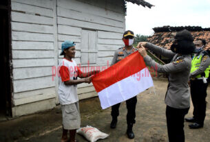 Wakapolres Kompol Eko Nugroho, SIK bersama Polwan dan Personel Polres mendistribusikan beras dan membagikan bendera merah putih kepada warga