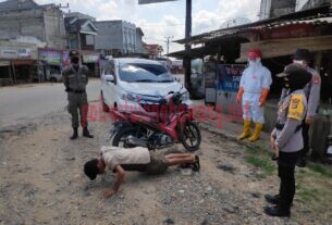 Petugas gabungan saat memberikan sanksi kepada buruh yang terjaring Operasi Yustisi di Kampung Sidoharjo