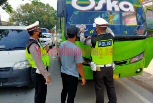 Personel Satlantas Polres Tulang Bawang sedang memasang stiker pada kendaraan bus saat menggelar Operasi Zebra Krakatau-2020 di Jalintim, Pasar Unit 2