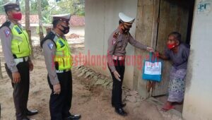Kasat Lantas Polres Tulang Bawang Iptu Ipran, SH saat memberikan paket sembako kepada warga di Kampung Bawang Tirto Mulyo, Kecamatan Banjar Baru
